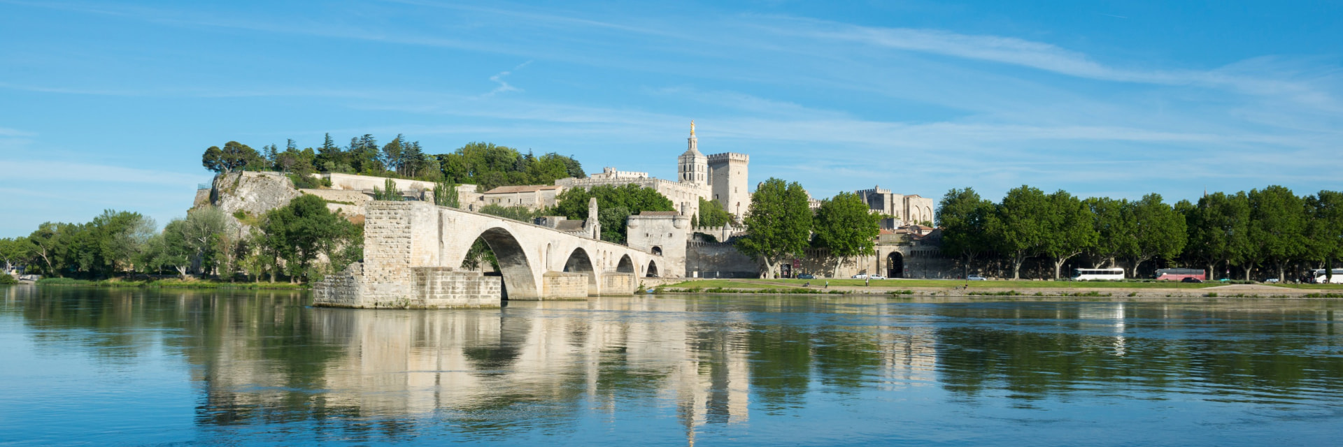 Avignon and its historic bridge reflected in the Rhône